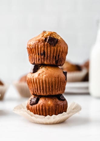 thee banana muffins with chocolate chunks stacked on top of each other