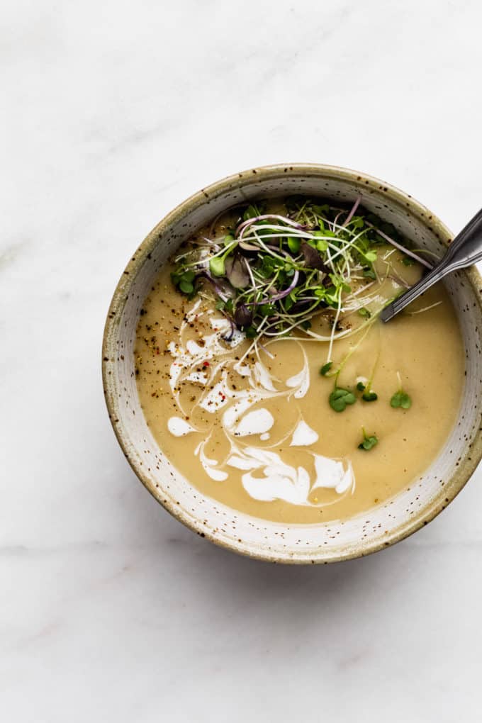 roasted garlic soup in a speckled light blue bowl