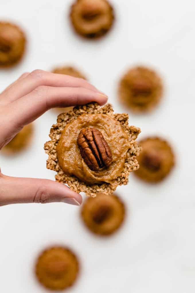 a hand holding up a mini pecan pie