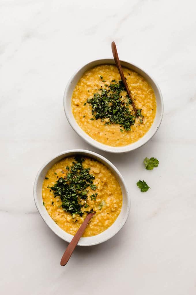 two bowls of aryuvedic khichdi topped with cilantro