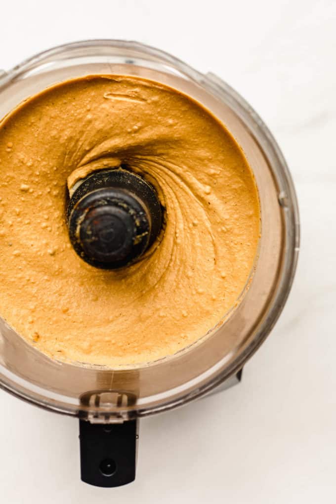 A food processor with roasted sweet potato hummus in it
