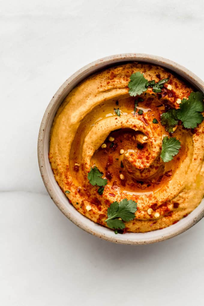 sweet potato hummus in a bowl topped with paprika and cilantro