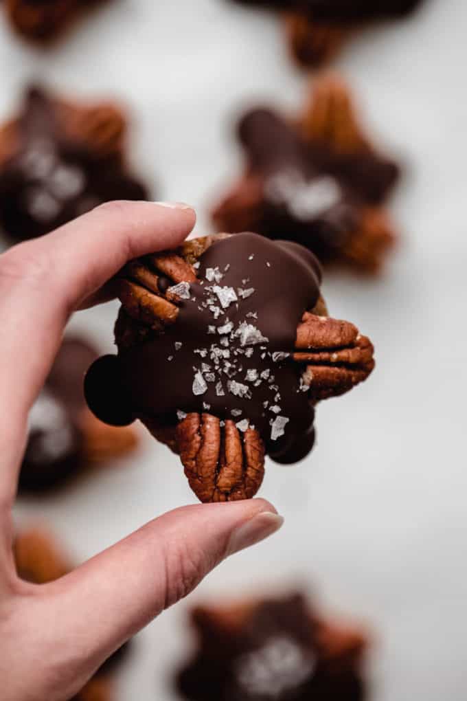 A hand holding a healthy chocolate turtle candy