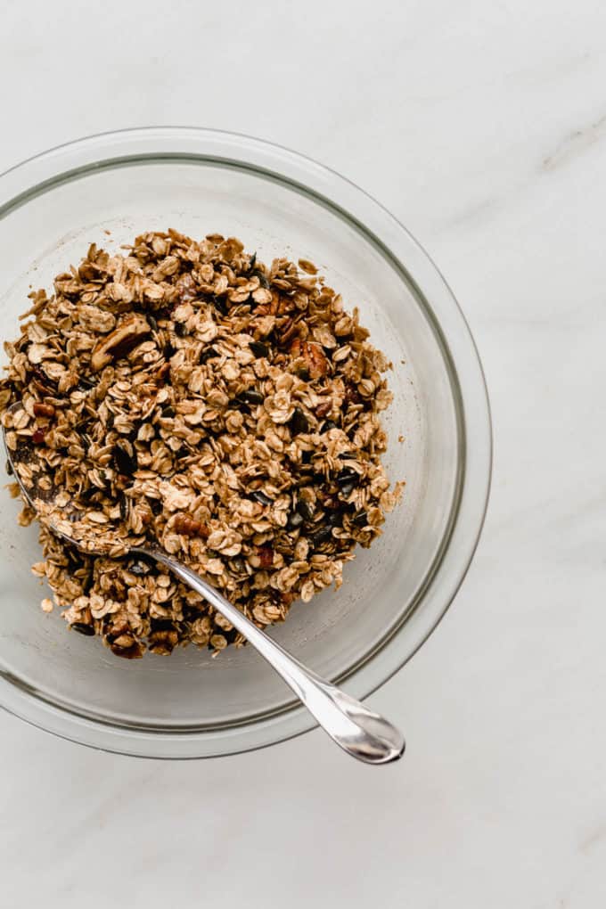 A clear mixing bowl with pumpkin spice granola in it