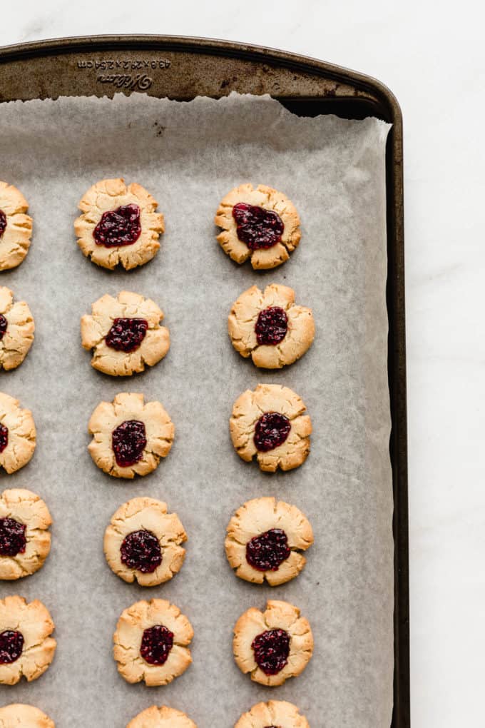a pan of baked thumbprint cookies with raspberry jam