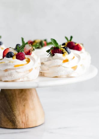 mini pavlovas on a marble and wood cake stand