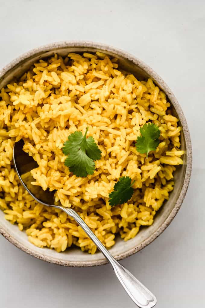 A bowl of turmeric rice topped with cilantro