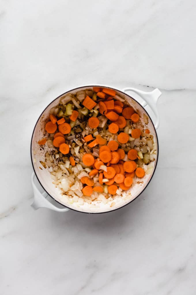 carrots and onions in a white pot