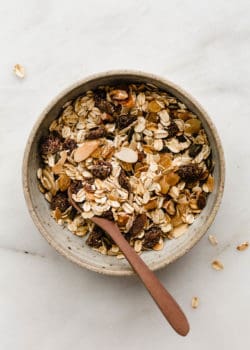 A bowl of muesli with a wooden spoon in it