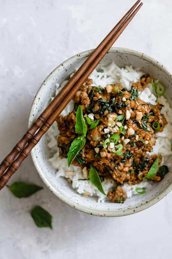 basil tempeh stir fry on rice in a light blue speckled bowl