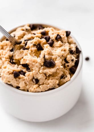 a close up of chocolate chip chickpea cookie dough in a small white bowl