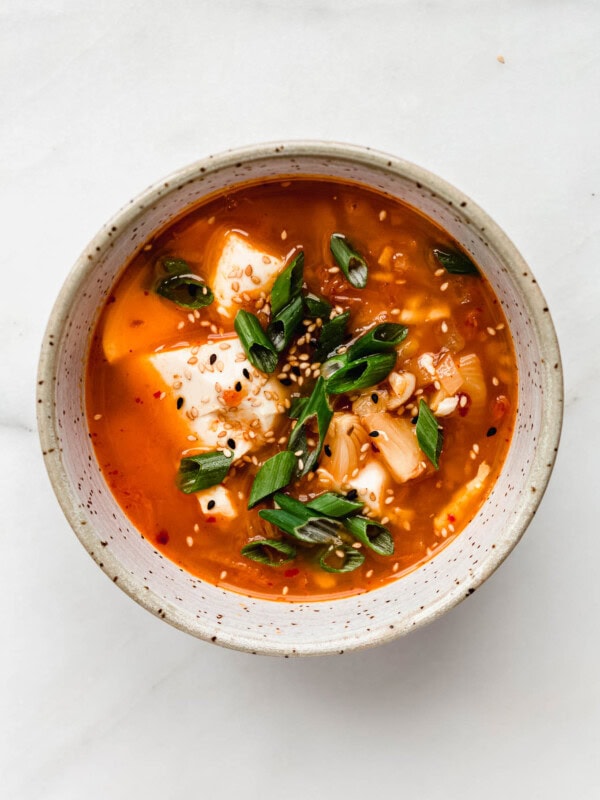 Korean Tofu Soup in a speckled bowl topped with green onions