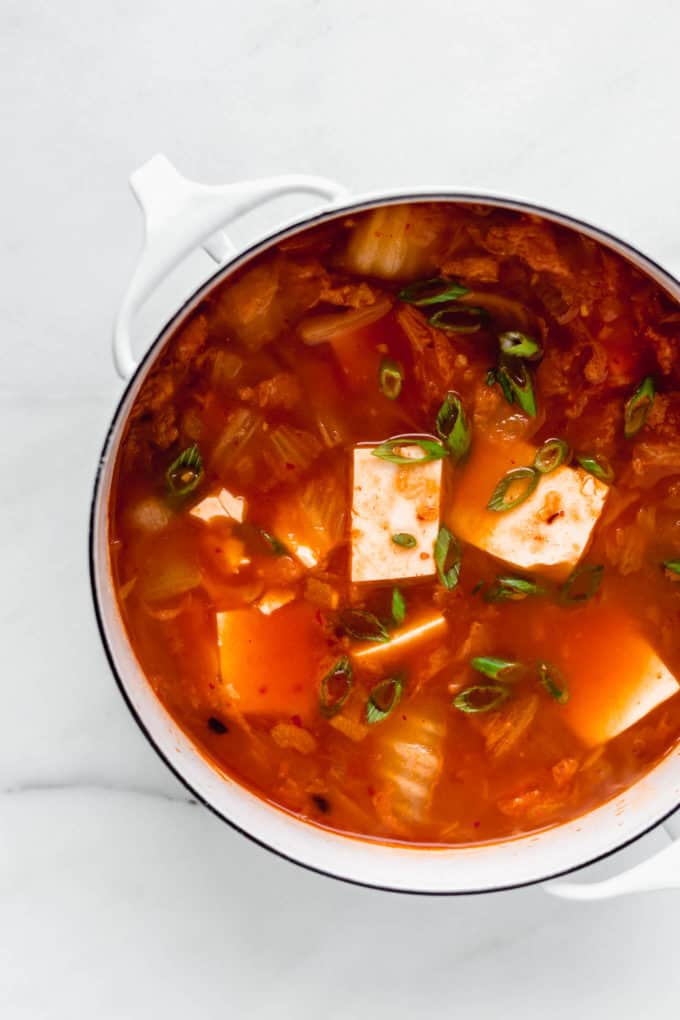 Korean Tofu Soup in a white pot topped with green onions