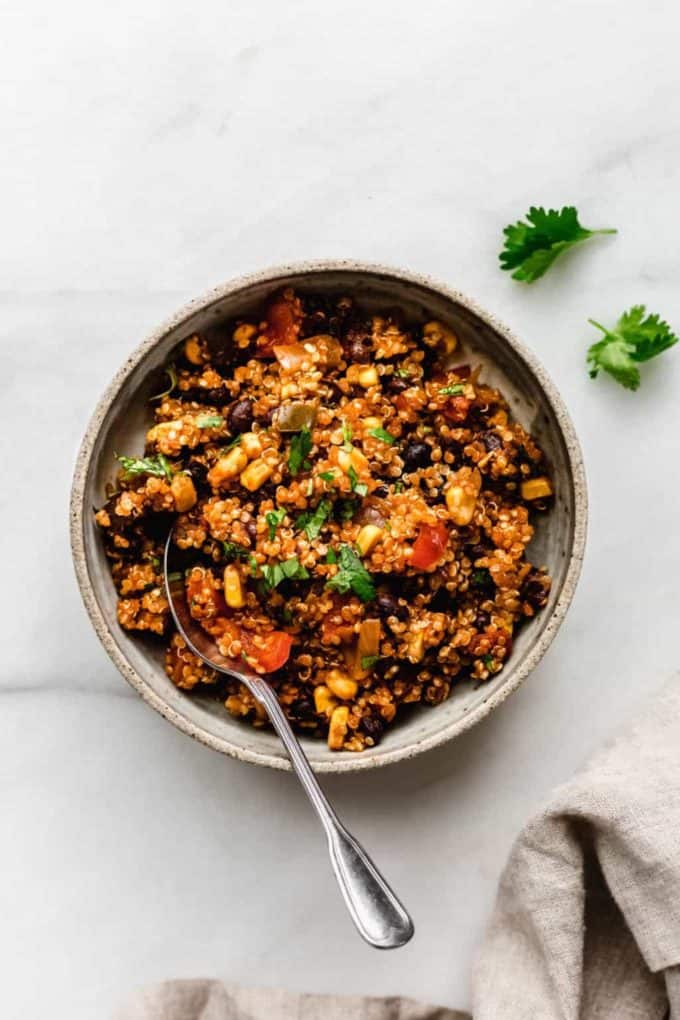 A bowl of Mexican quinoa with a spoon in it