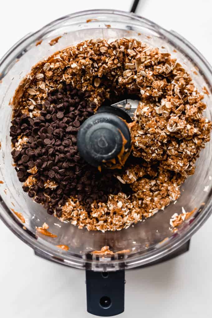 a food processor with oats, peanut butter and chocolate chips in it