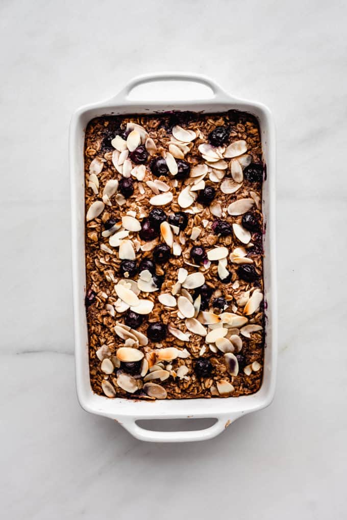 baked oatmeal in a white baking dish topped with blueberries