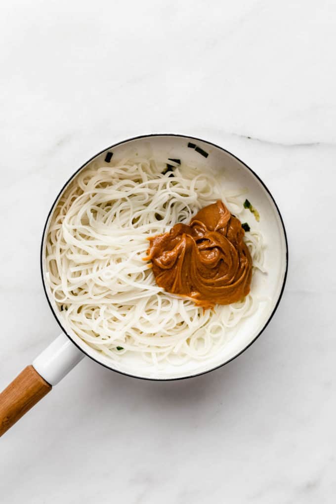 Rice noodles and peanut sauce in a white pot