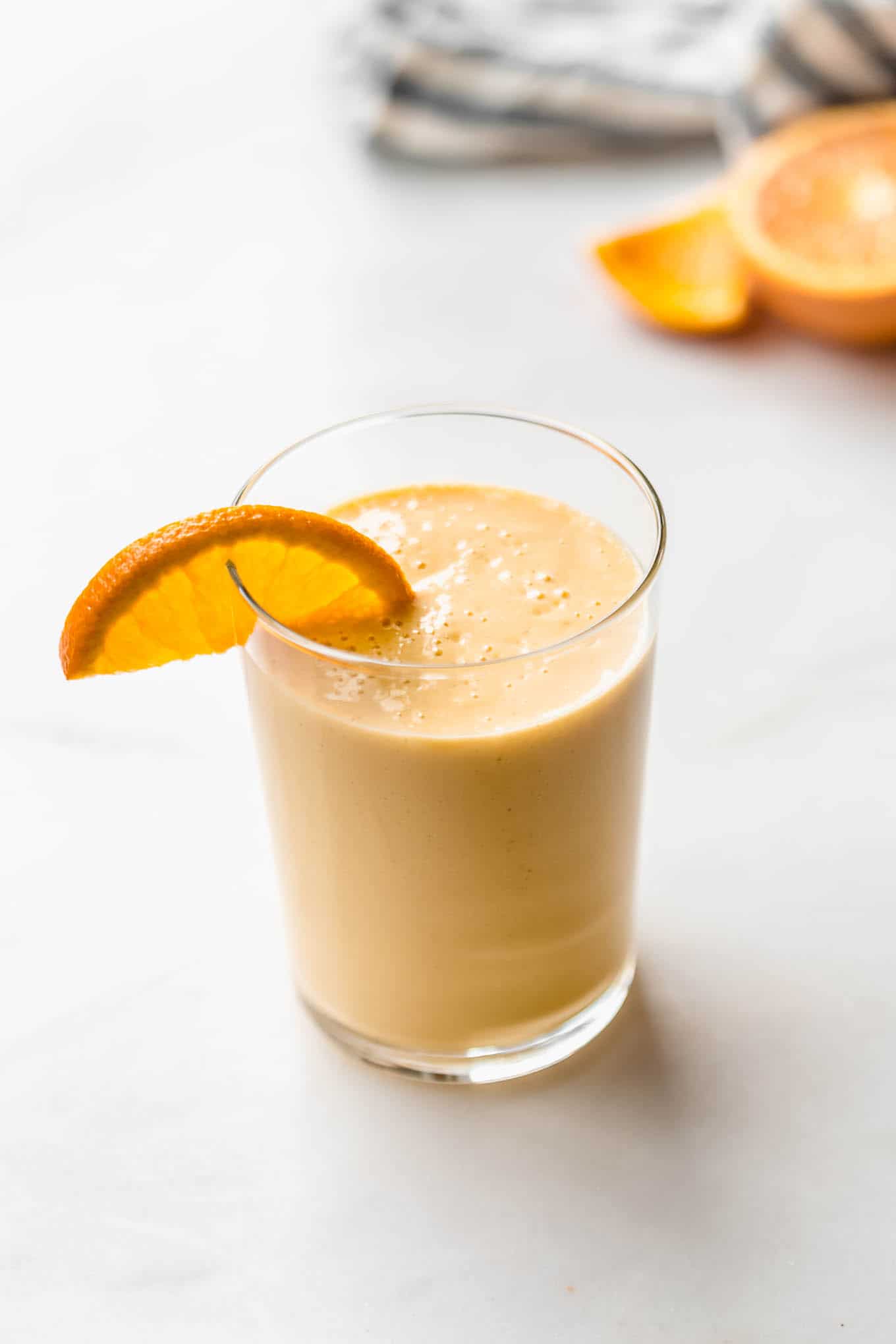 an orange creamsicle smoothie with an orange slice in it