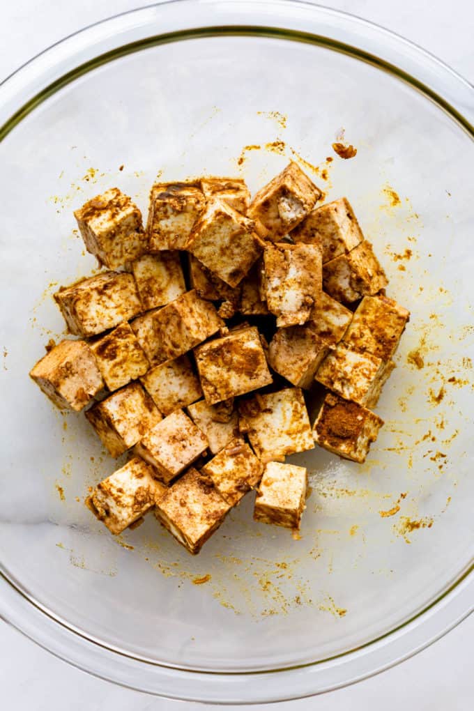 a bowl of tofu cubes in satay marinade