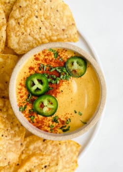 A bowl of dairy-free queso cheese topped with sliced jalapenos