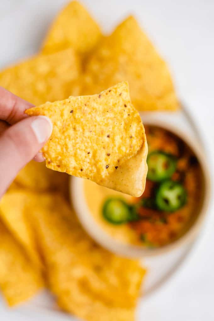 a tortilla corn chip with vegan queso on it