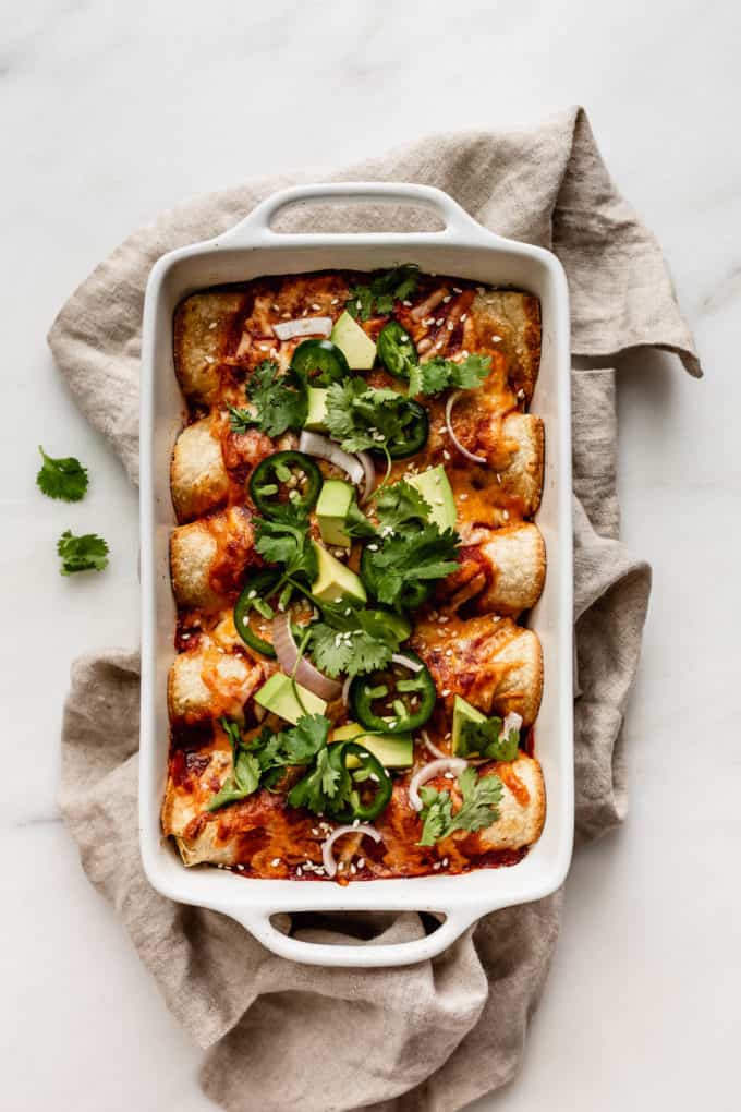 A dish of vegetable enchiladas on a beige napkin