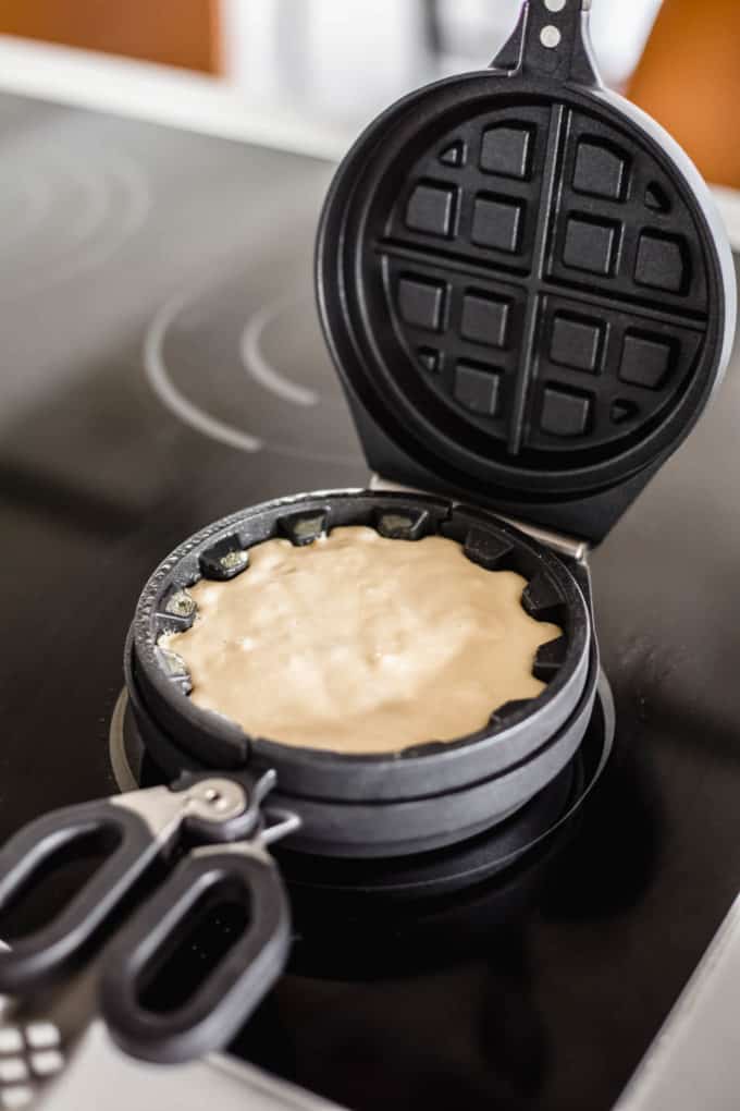 A waffle iron with waffle batter in it