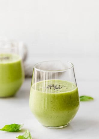 Two glasses with green smoothie in them topped with chia seeds