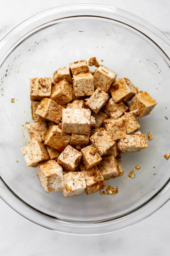 cubed tofu covered in marinate in a bowl