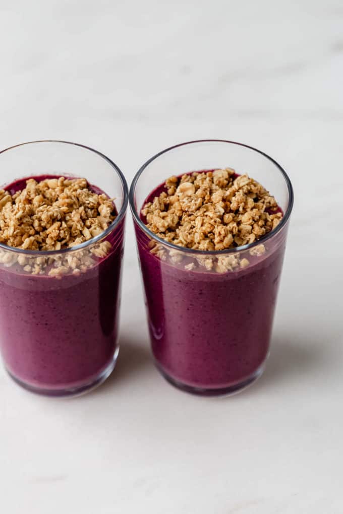 two glasses of acai smoothie topped with granola