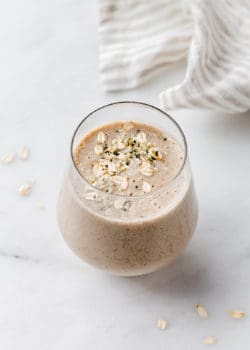 a banana bread smoothie in a glass on a marble counter