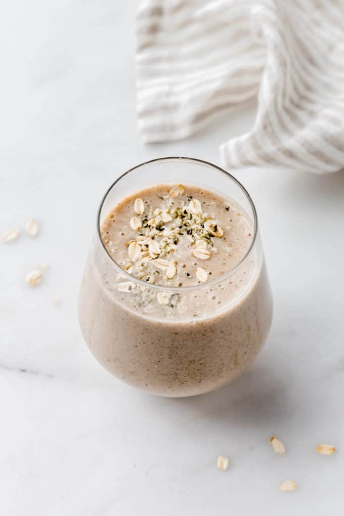 a banana bread smoothie in a glass on a marble counter