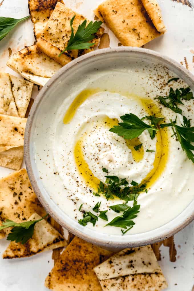 feta dip in a bowl surrounded by pita chips