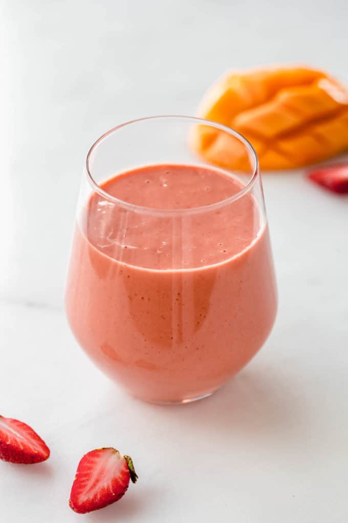 a strawberry mango smoothie with strawberries on the side