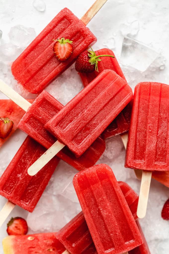 strawberry watermelon popsicles stacked on top of each other on ice