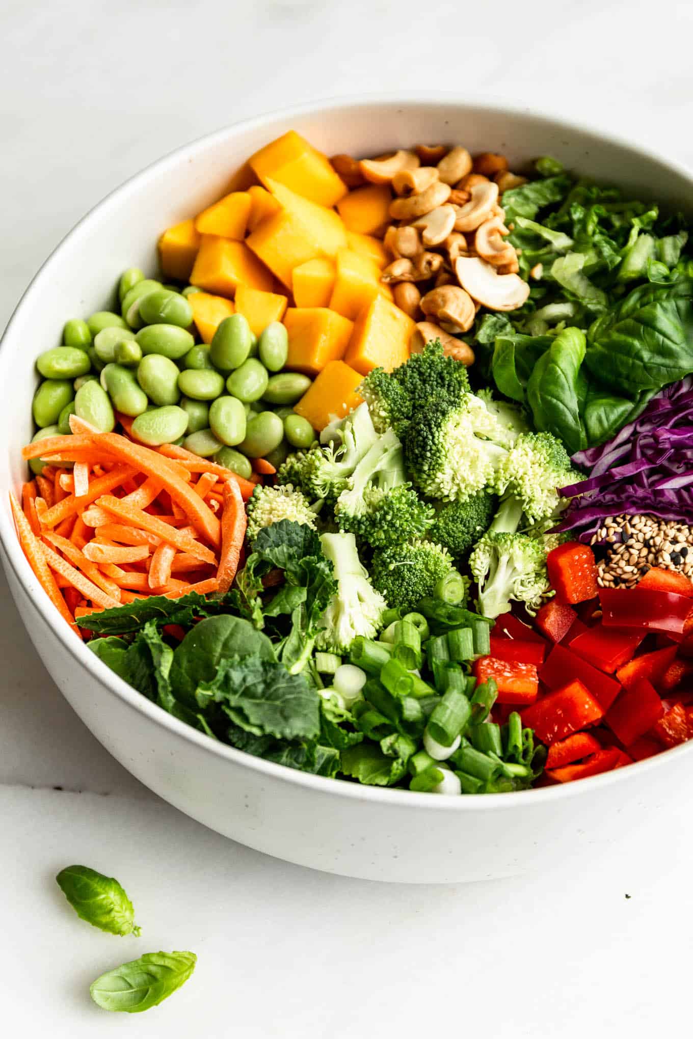 Thai Crunch Salad ingredients in a white serving bowl on a marble counter