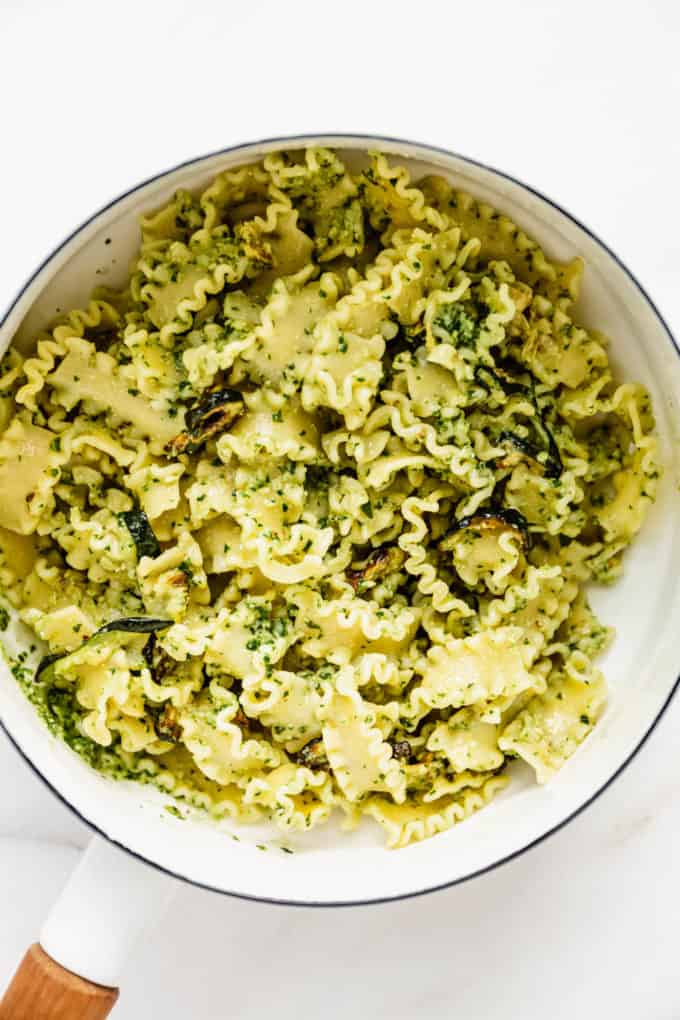 Noodles with pesto on them in a white pot