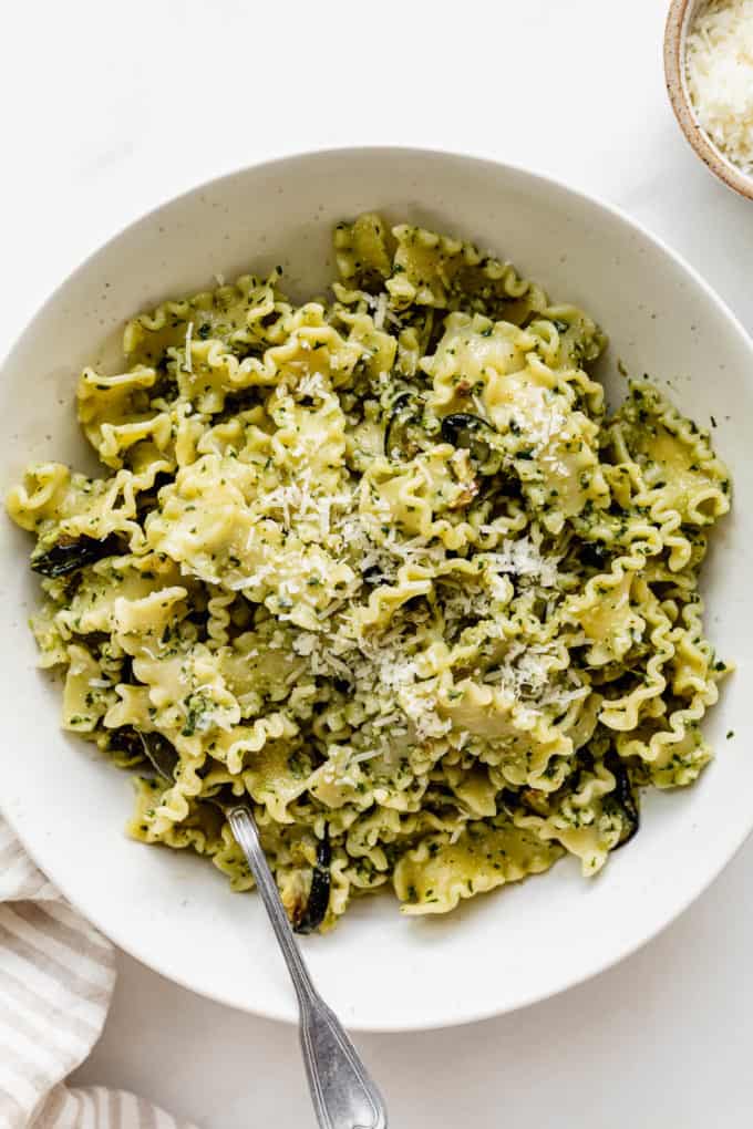 Pesto pasta in a bowl with a fork in it