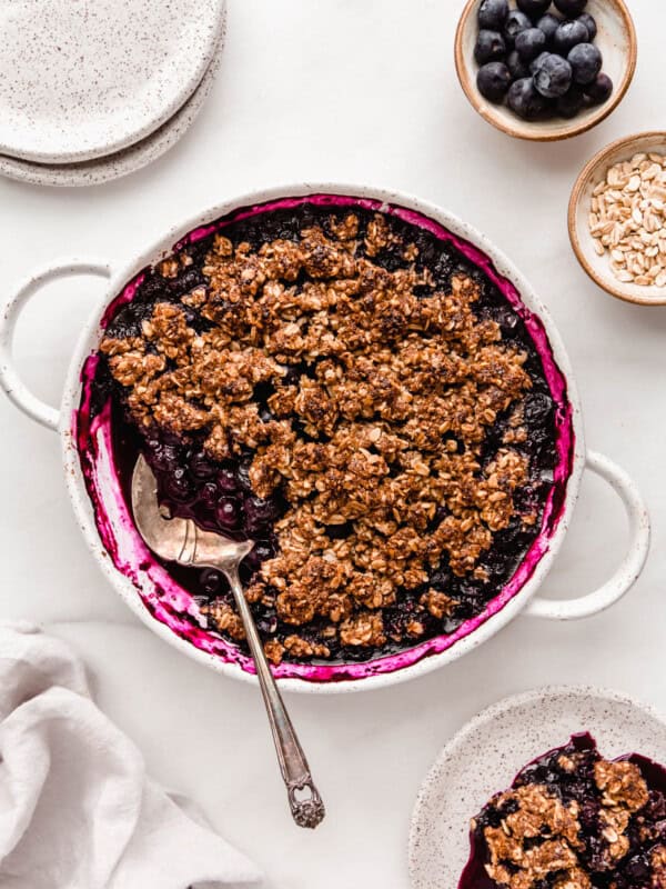 A blueberry crisp dishes and a napkin on the side