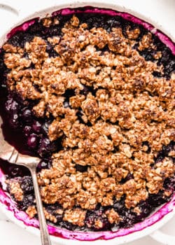 healthy blueberry crisp with a serving spoon in it