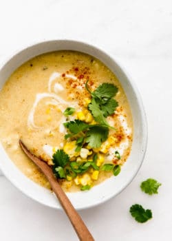 A bowl of vegan corn chowder topped with corn and cilantro