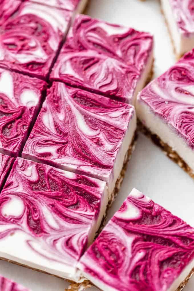 Sliced vegan raspberry cheesecake bars cut in squares