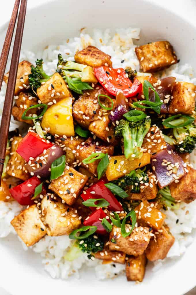 Tofu stir fry with broccoli and peppers topped with sesame seeds