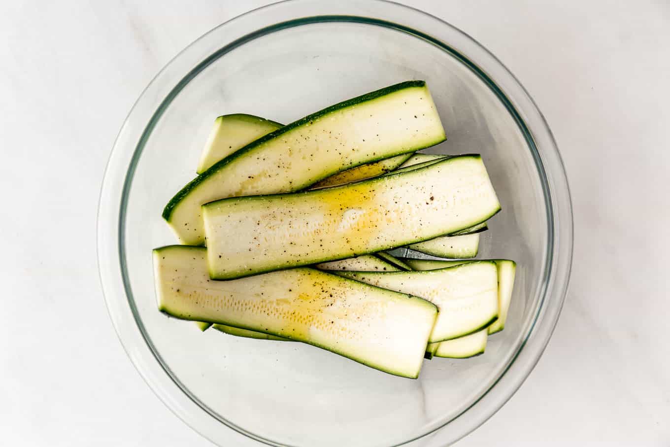 Slices of zucchini in a clear mixing bowl