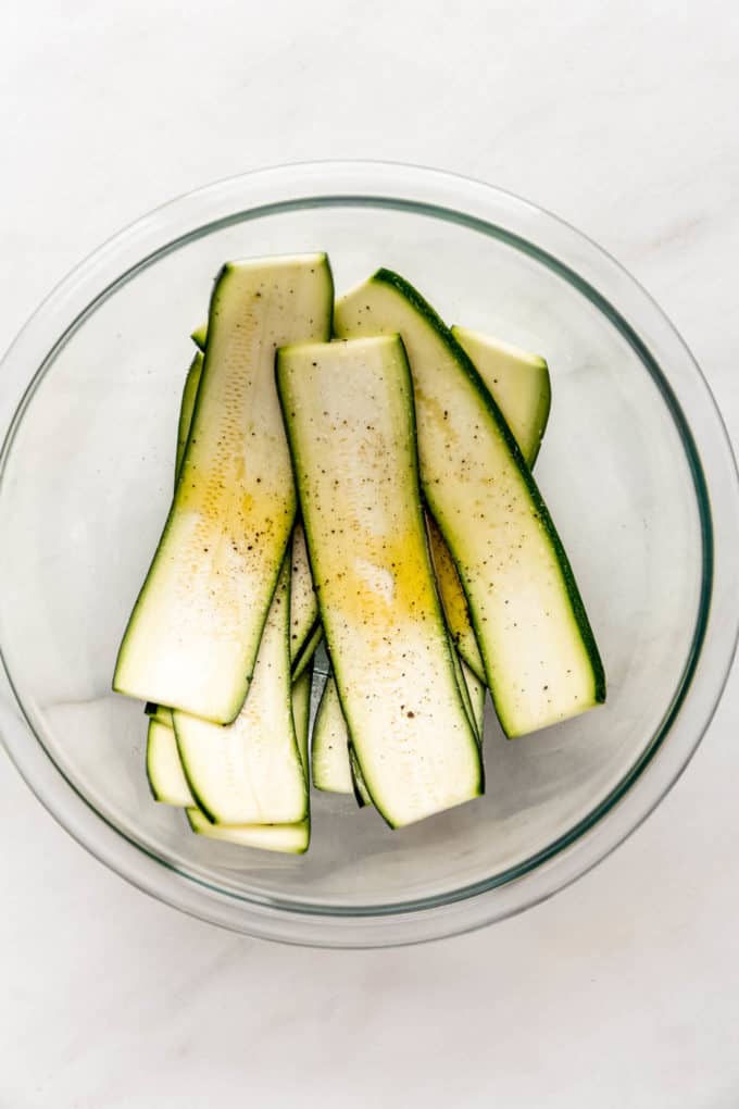 Zucchini with olive oil in a mixing bowl