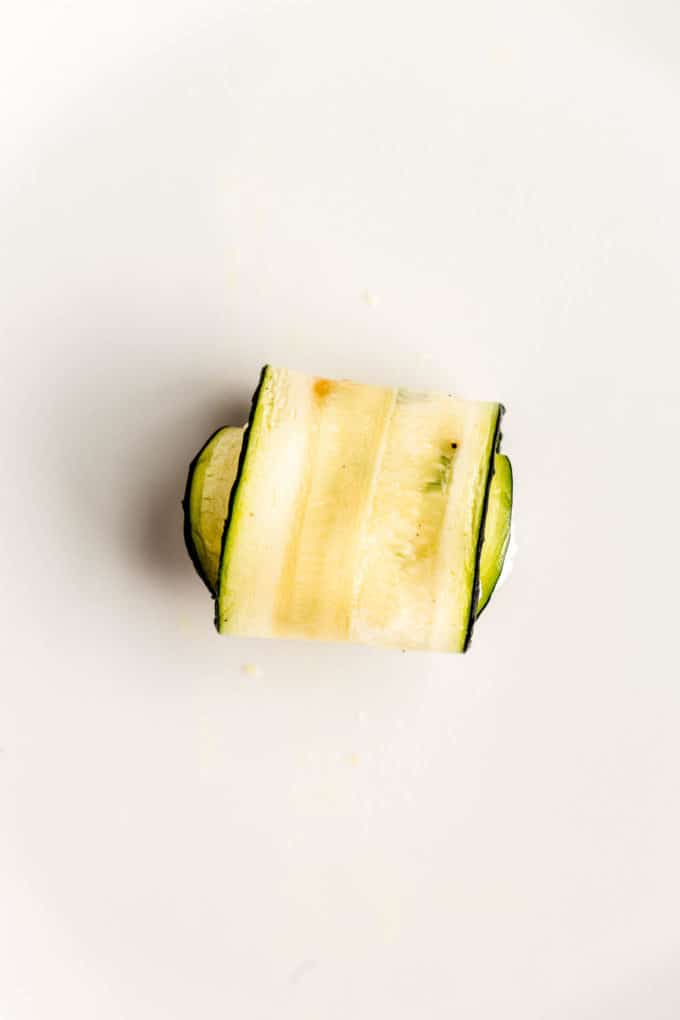 A slice of zucchini rolled up with ricotta stuffing in it
