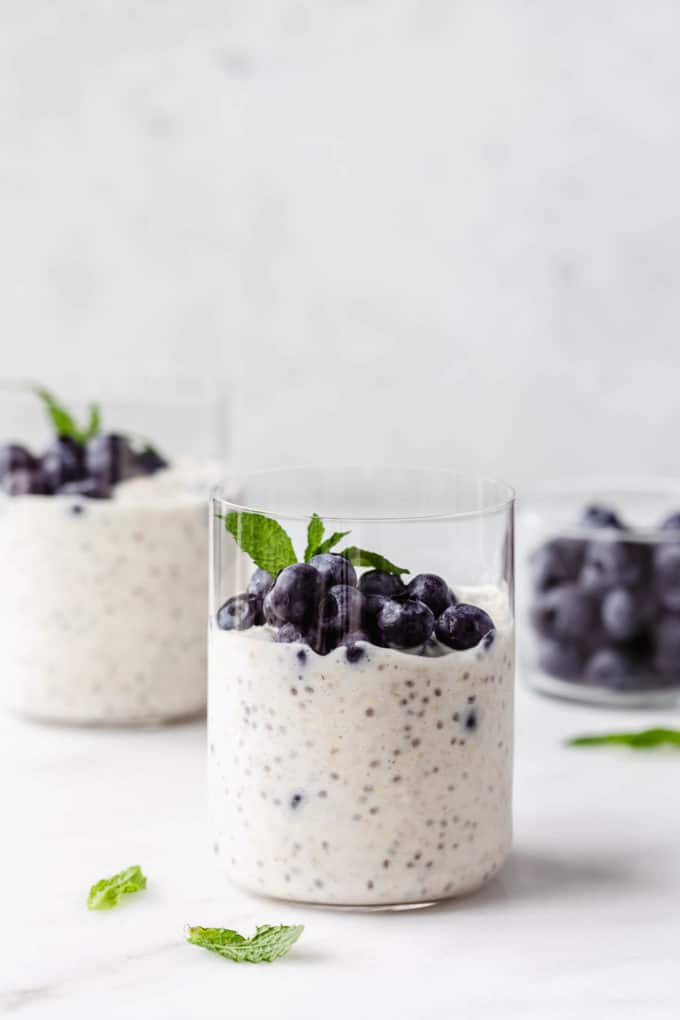 two cups of blueberry overnight oats topped with fresh mint