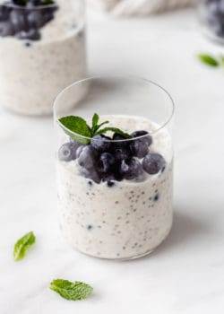 overnight oats in a cup topped with blueberries and mint