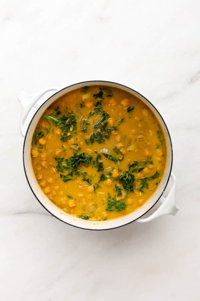 Coconut curry chickpeas with kale in a white pot