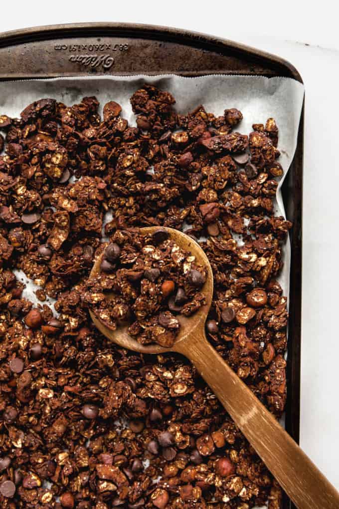 A wooden spoon in a pan with chocolate granola in it